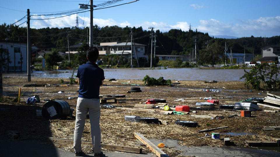 A man, pictured here looking at debris in the aftermath of Typhoon Hagibis.