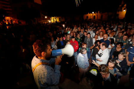 A man uses a megaphone as people gather outside industrial school that is a polling station for the banned independence referendum in Barcelona, Spain, October 1, 2017. REUTERS/Yves Herman