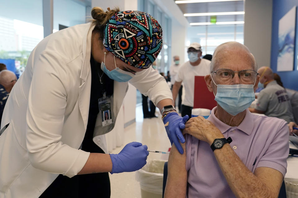 FILE - In this Jan. 27, 2021, file photo, Dean Coleman, right, receives the Pfizer-BioNTech COVID-19 vaccine from graduate student Nina Cruz, left, at the Jackson Hospital in Miami. The Associated Press was given exclusive access to a recent day of vaccinations at Jackson Memorial hospital system. (AP Photo/Lynne Sladky, File)