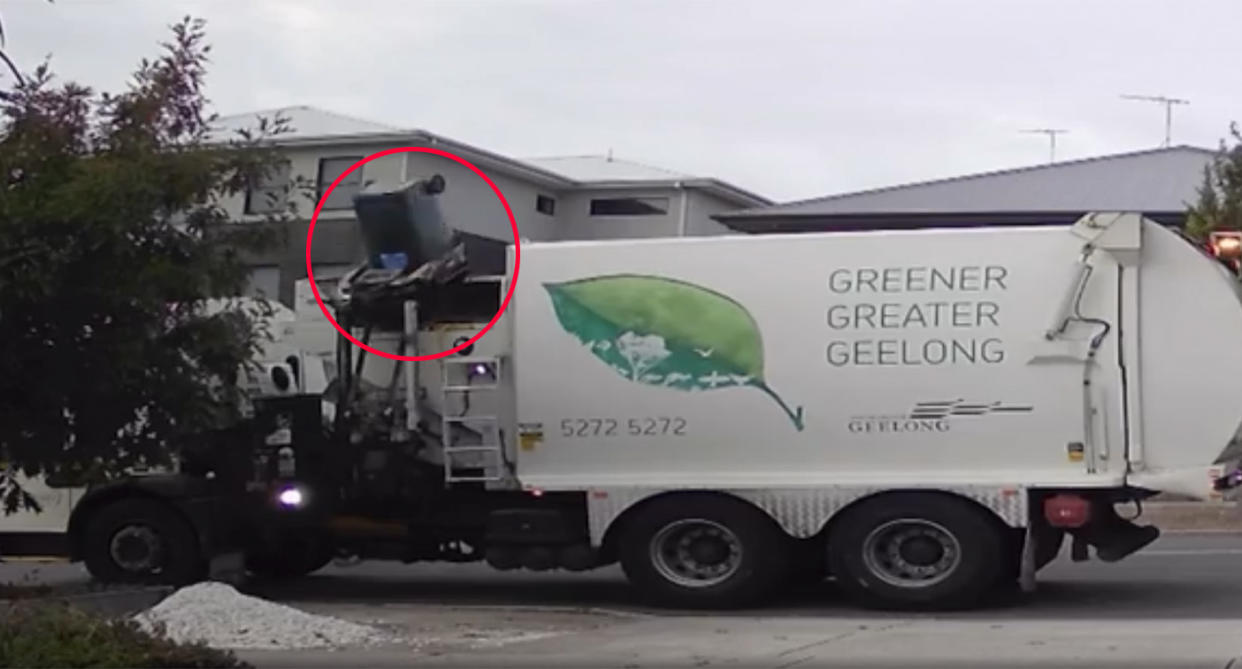 Garbage truck collecting rubbish from wheelie bin