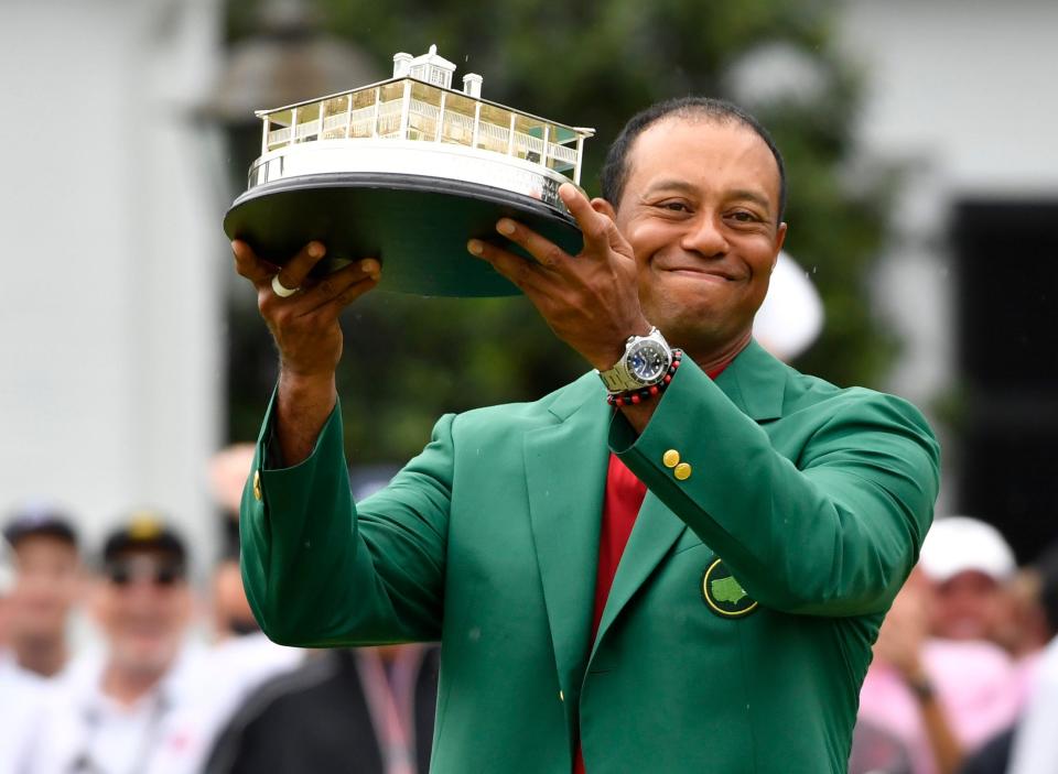 Tiger Woods celebrates with the green jacket and trophy after winning The Masters golf tournament at Augusta National Golf Club. Mandatory Credit: Michael Madrid-USA TODAY Sports