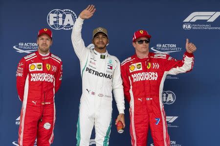 Oct 20, 2018; Austin, TX, USA; Ferrari driver Sebastian Vettel of Germany (left) and Mercedes driver Lewis Hamilton of Great Britain (center and Ferrari driver Kimi Raikkonen (7) of Finland wave to the crowd after Hamilton takes the pole position during qualifying for the Unites States Grand Prix at Circuit of the Americas. Mandatory Credit: Jerome Miron-USA TODAY Sports