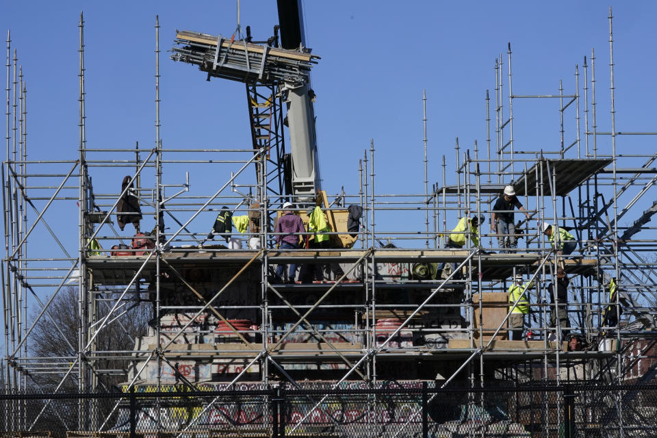 Workers continue to dismantle the pedestal that once held the statue of Confederate General Robert E. Lee on Monument Avenue Tuesday Dec 14, 2021, in Richmond, Va. Virginia Gov. Ralph Northam ordered the pedestal removed and property given to the City of Richmond. (AP Photo/Steve Helber)