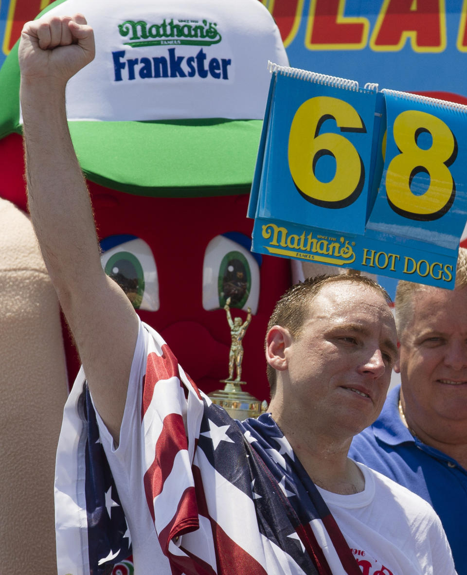 Five-time reigning champion Joey Chestnut celebrates after he wins his sixth Nathan's Famous Hot Dog Eating World Championship with a total of 68 hot dogs and buns, Wednesday, July 4, 2012, at Coney Island, in the Brooklyn borough of New York. (AP Photo/John Minchillo)