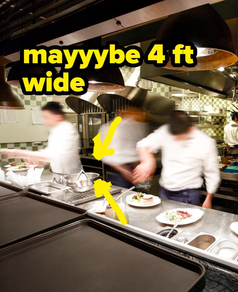 Chefs in a busy kitchen prepare and plate food, their movements blurred by activity