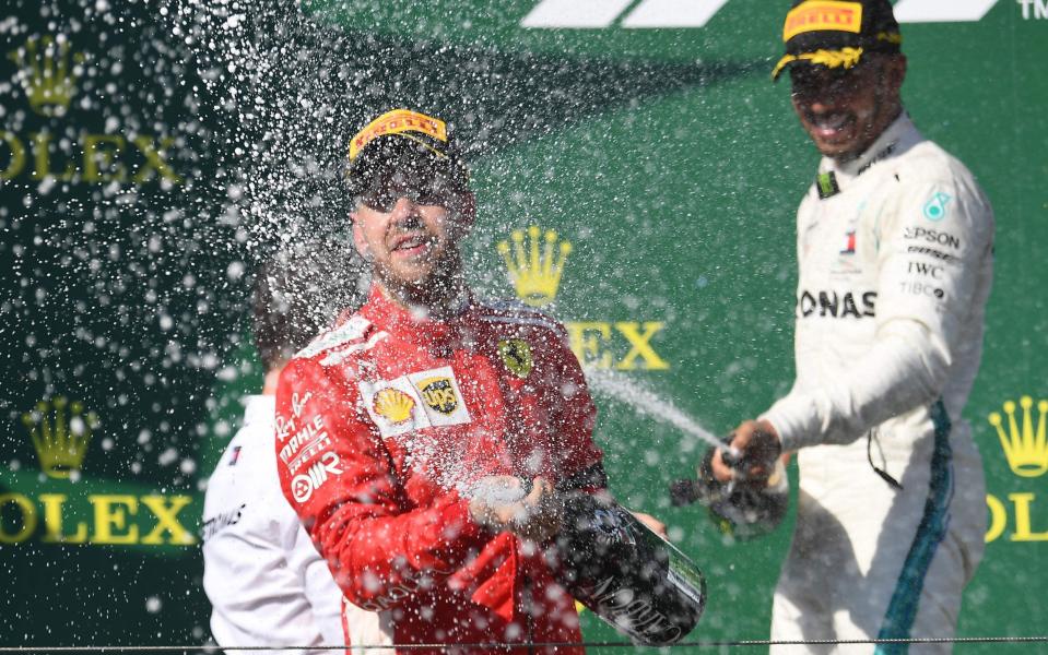 Mercedes' British driver Lewis Hamilton (R) and second placed Ferrari's German driver Sebastian Vettel celebrate on the podium as they spray with Champagner after the Formula One Hungarian Grand Prix - ATTILA KISBENEDEK/AFP/Getty Images