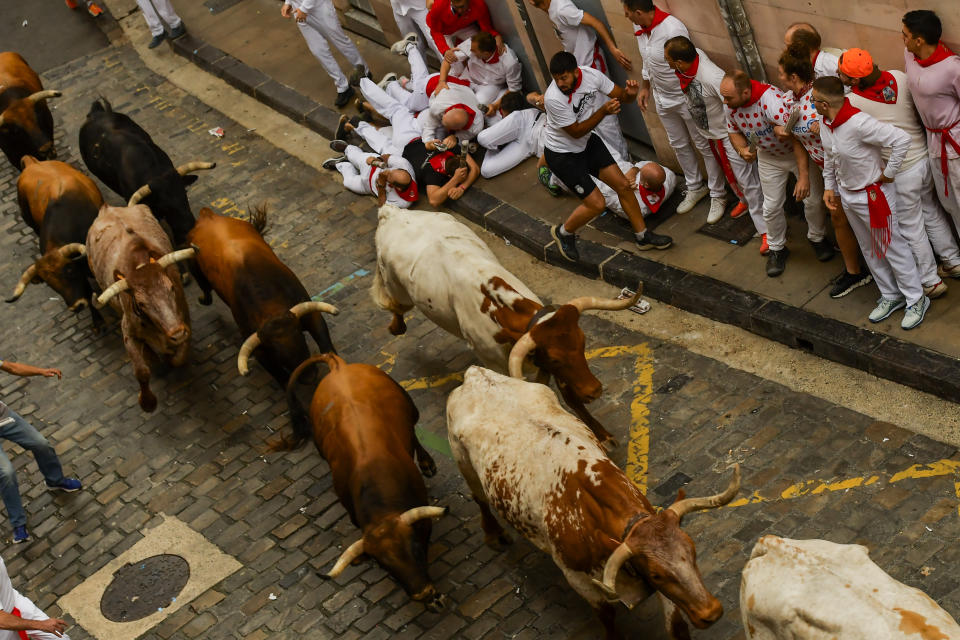 La Palmosilla's fighting bulls run among revellers during the first day of the running of the bulls during the San Fermin fiestas in Pamplona, Spain, Friday, July 7, 2023. (AP Photo/Alvaro Barrientos)