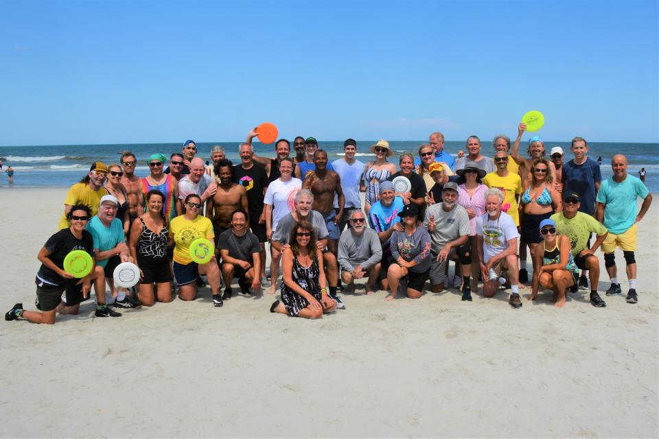 Paul Kenny, bottom center, gathers with other freestyle Frisbee players at his Memorial Day Jam in Jacksonville Beach this year.