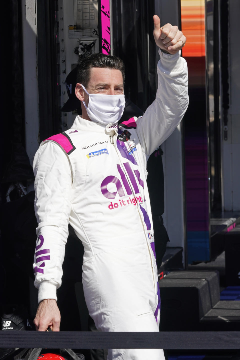 Simon Pagenaud, of France, gives the thumbs up to fans cheering him from the Fan Zone after a practice session for the Rolex 24 hour race at Daytona International Speedway, Friday, Jan. 29, 2021, in Daytona Beach, Fla. (AP Photo/John Raoux)