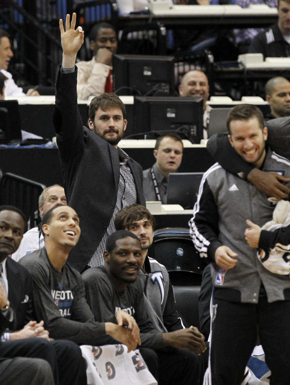 Minnesota Timberwolves forward Kevin Love cheers on his teammates from the bench during the first quarter of an NBA basketball game against the Houston Rockets in Minneapolis, Friday, April 11, 2014. Love was out with a hyper-extended right elbow. (AP Photo/Ann Heisenfelt)