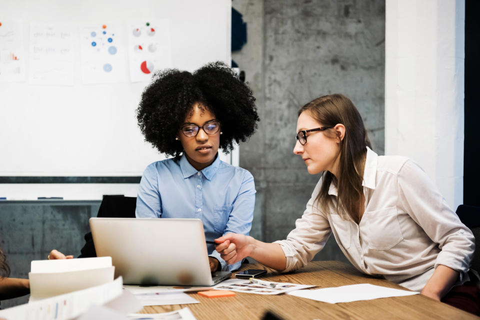 Two women at an office have a discussion in a meeting