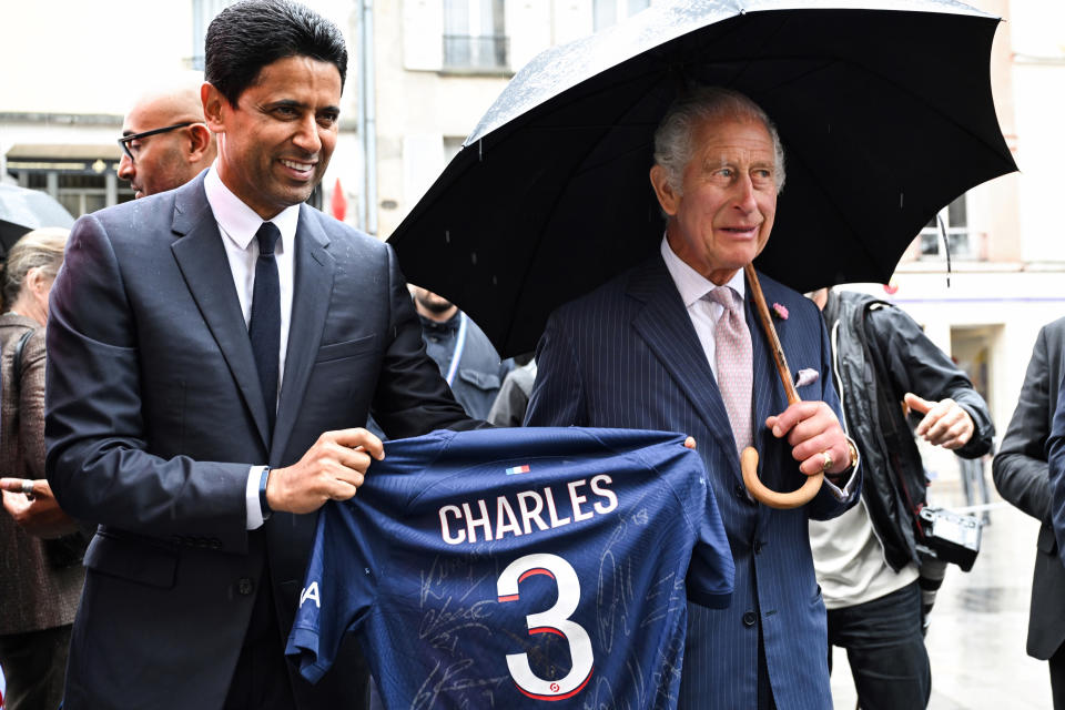 Paris Saint Germain's president Nasser Al-Khelaifi offers Britain's King Charles III a PSG jersey, Thursday, Sept. 21, 2023 in Saint-Denis, outside Paris. On the second day of his state visit to France, King Charles met with sports groups in the northern suburbs of Paris and was scheduled to pay a visit to fire-damaged Notre-Dame cathedral. (Bertrand Guay, Pool via AP)