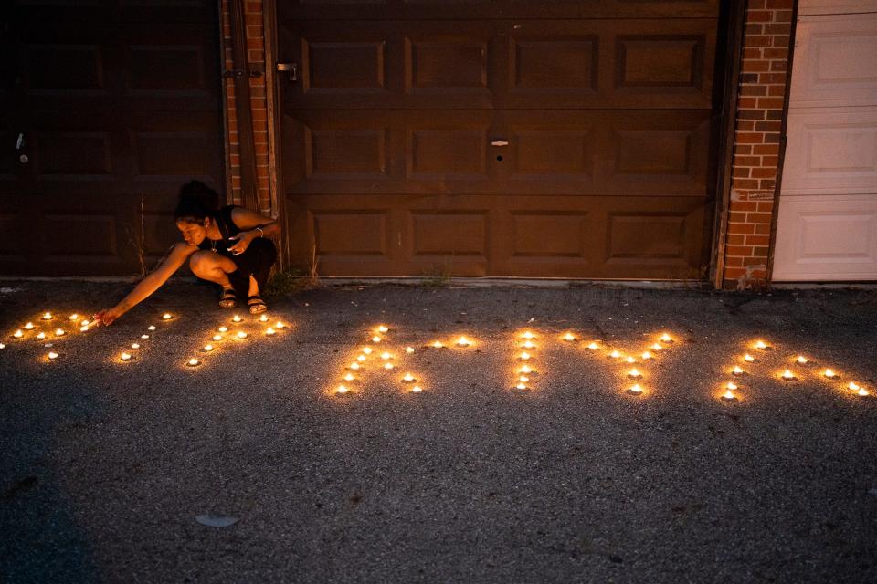 Sandriana McBroom, 22, lights candles that spell out "RIP Kiya" at a vigil Friday for Ta'Kiya Young, 21, whom Blendon Township police shot and killed Thursday outside the Sunbury Road Kroger. Young was pregnant with her third child, a girl, and was due to give birth in November, according to family.