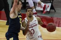 Wisconsin's D'Mitrik Trice drives past Michigan's Franz Wagner during the second half of an NCAA college basketball game Sunday, Feb. 14, 2021, in Madison, Wis. (AP Photo/Morry Gash)