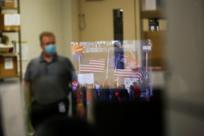 FILE PHOTO: Protesting supporters of U.S. President Donald Trump are reflected in a window at the Maricopa County Tabulation and Election Center