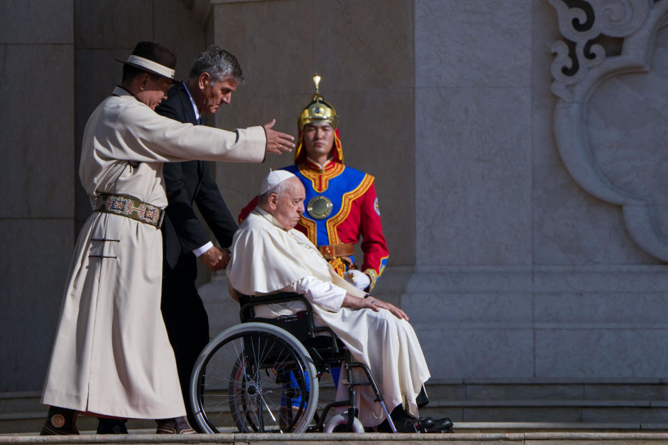 Mongolian President Ukhnaagin Khurelsukh, left, welcomes Pope Francis and his aide Sandro Mariotti, Saturday, Sept. 2, 2023, in front of the Saaral Ordon Government Building in Sukhbaatar Square in Ulaanbaatar. Pope Francis arrived in Mongolia on Friday morning for a four-day visit to encourage one of the world's smallest and newest Catholic communities. (AP Photo/Ng Han Guan)