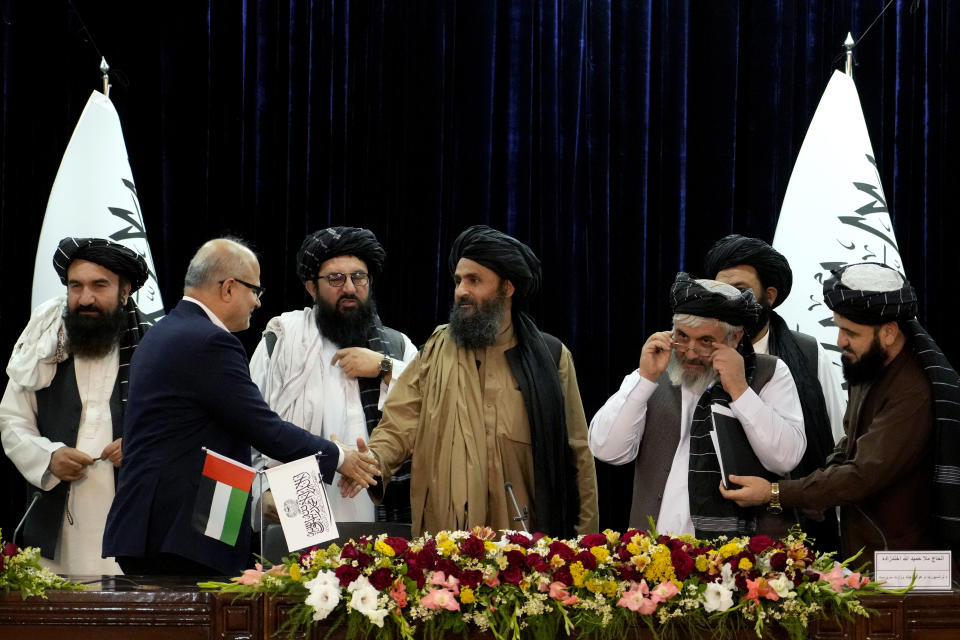 Mullah Abdul Ghani Baradar, Acting Deputy Prime Minister of the Afghan Taliban's caretaker government, center, and the chief financial officer of GAAC Solutions, Razack Aslam Mohammed Abdur Razack, shake hands after signing documents in Kabul, Afghanistan, Tuesday, May 24, 2022. The Taliban said Tuesday that they've signed a deal allowing Abu Dhabi-based GAAC Solutions to manage the airports in Herat, Kabul and Kandahar. (AP Photo/Ebrahim Noroozi)