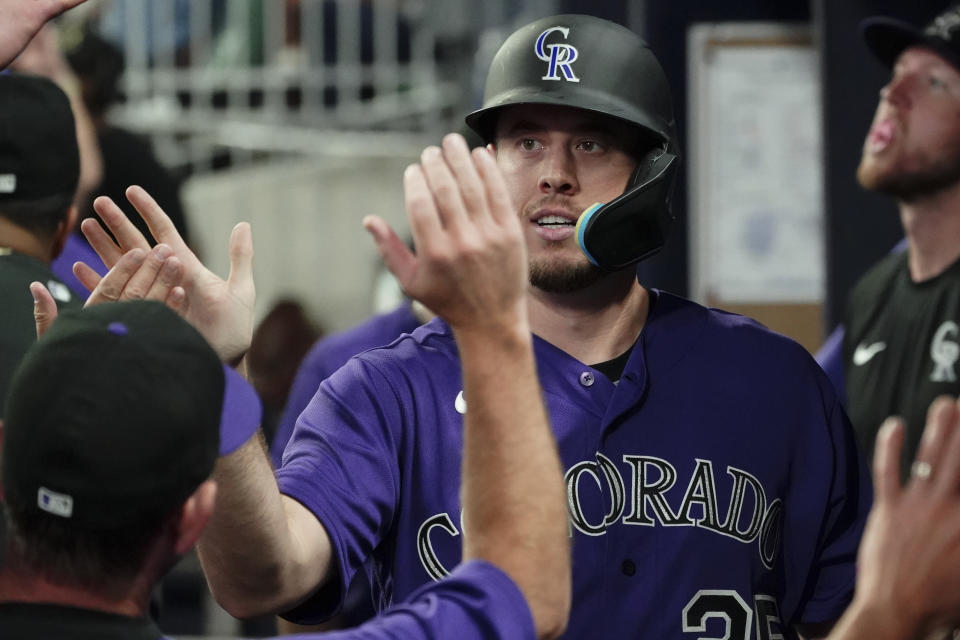 Colorado Rockies' C.J. Cron (25) celebrates in the dugout after scoring on an Elehuris Montero double during the fourth inning of the team's baseball game against the Atlanta Braves on Tuesday, Aug. 30, 2022, in Atlanta. (AP Photo/John Bazemore)