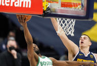 Boston Celtics guard Kemba Walker, left, drives to the rim as Denver Nuggets center Nikola Jokic, right, defends in the first half of an NBA basketball game Sunday, April 11, 2021, in Denver. (AP Photo/David Zalubowski)