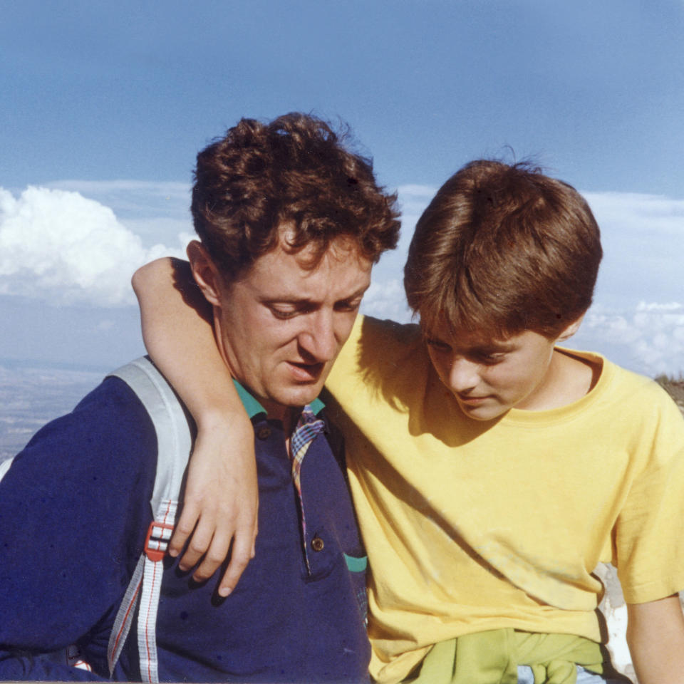 boy with his arm around his father's neck