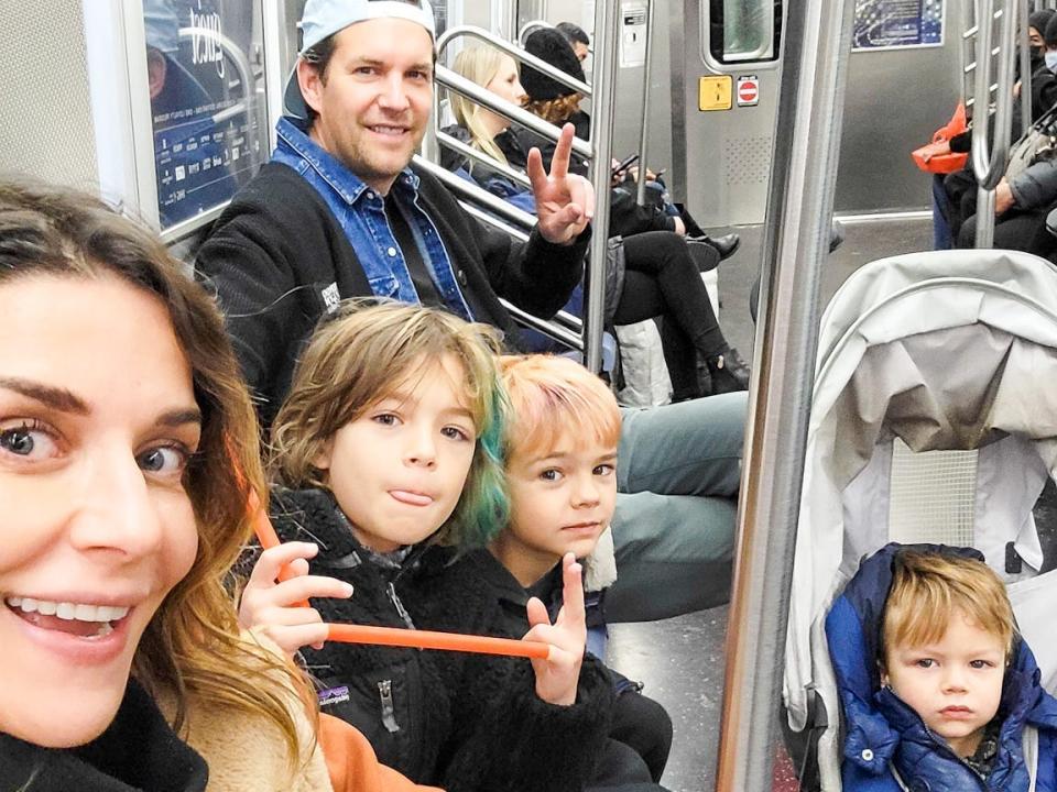 A family of five sitting on the subway in New York City.