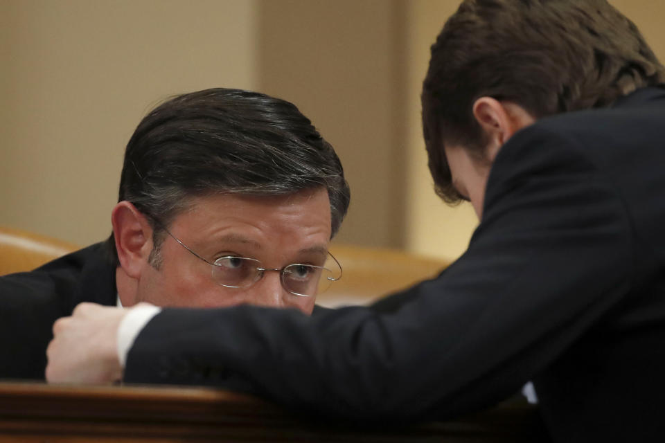 Rep. Mike Johnson, R-La., talks to a staff member during a House Judiciary Committee markup of the articles of impeachment against President Donald Trump, on Capitol Hill, Thursday, Dec. 12, 2019, in Washington. (AP Photo/Alex Brandon)