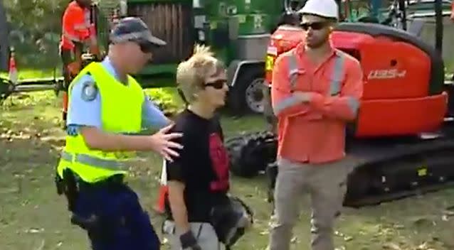 A protester offers no resistance as police escort her away from workers on Wednesday. Photo: 7 News