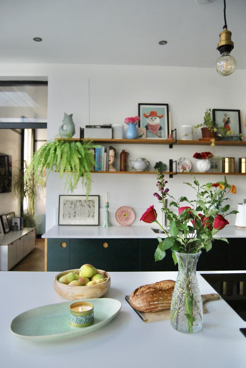 Bread, flowers other decorative items on the kitchen counter.