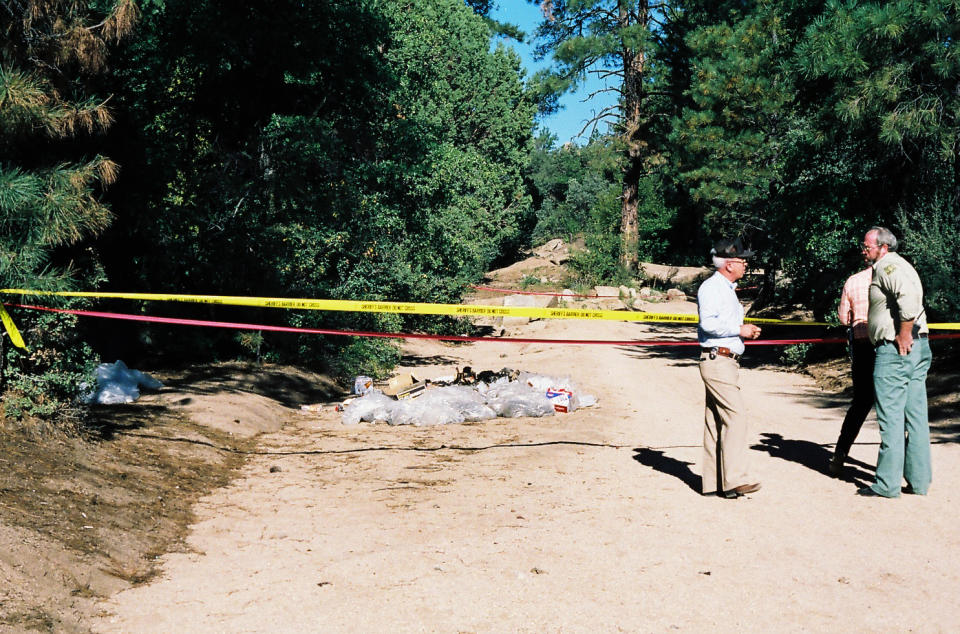 This undated photo provided by the Yavapai County Sheriff's Office shows authorities at the site outside Prescott, Ariz., where Pamela Pitts' body was found in 1988 among a pile of trash. Pitts' then-roommate, Shelly Harmon, recently confessed to killing her and was sentenced to time she already had served in another killing. (Yavapai County Sheriff's Office via AP)