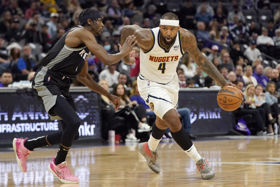 Denver Nuggets center DeMarcus Cousins (4) drives against Sacramento Kings forward Justin Holiday during the first half of an NBA basketball game in Sacramento, Calif., Wednesday, March 9, 2022. (AP Photo/Jeff Chiu)