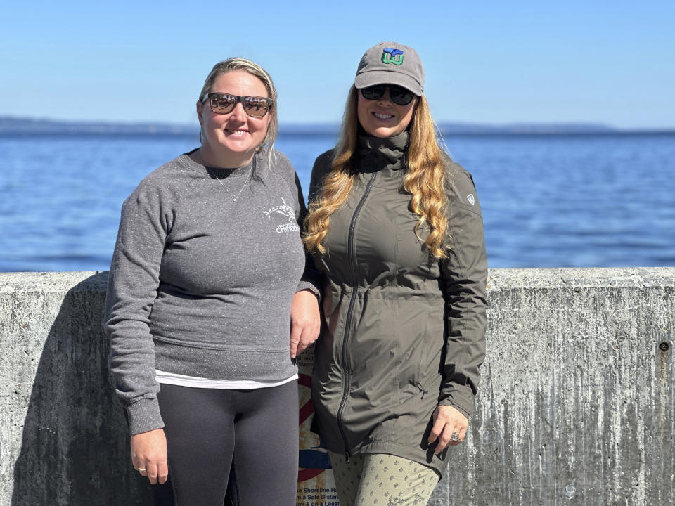 Kersti Muul, right, and Brittany Philbin pose for a portrait at Alki beach in Seattle, on August 4, 2023. Muul created "Salish Wildlife Watch" – a WhatsApp group chat that alerts people in the Seattle area when whales are close to the city. Philbin, an emergency hospital nurse, helps run the group chat as a volunteer. (AP Photo/Manuel Valdez)
