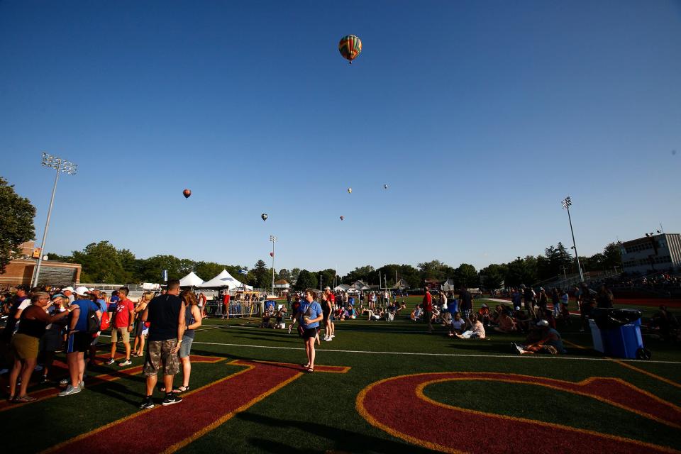 Hot air balloons fly above RAGBRAI riders in Indianola.