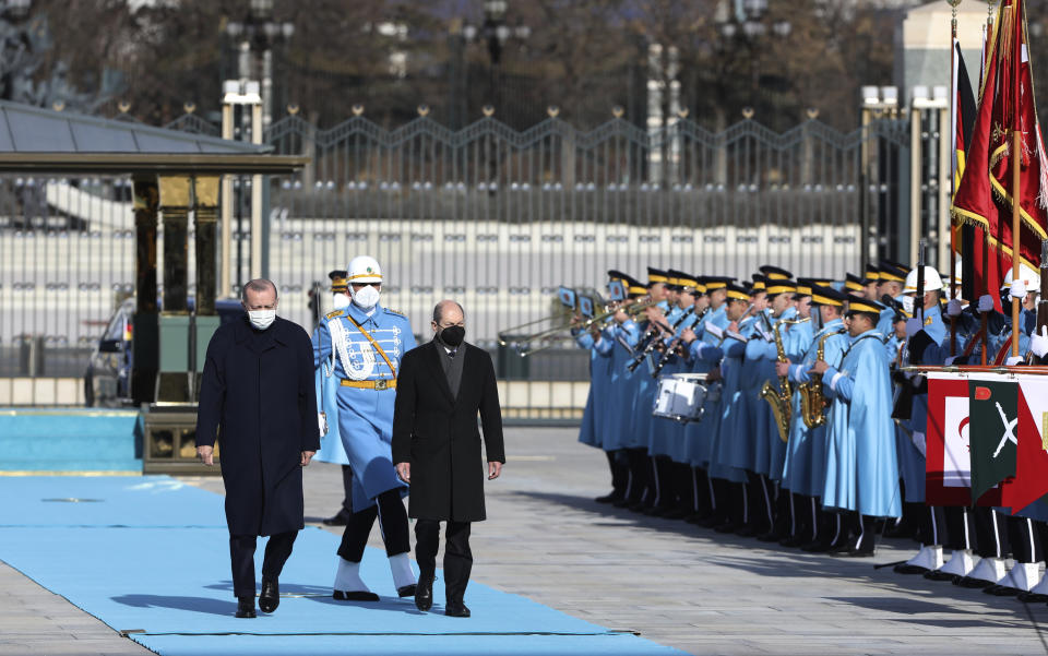 Turkish President Recep Tayyip Erdogan, left, and Germany's Chancellor Olaf Scholz review a military honour guard during a ceremony in Ankara, Turkey, Monday, March 14, 2022. Scholz is visiting Turkey Monday in his first official trip to the country since he took office in December. He will hold talks with Turkish President Recep Tayyip Erdogan in Ankara. (AP Photo/Burhan Ozbilici)