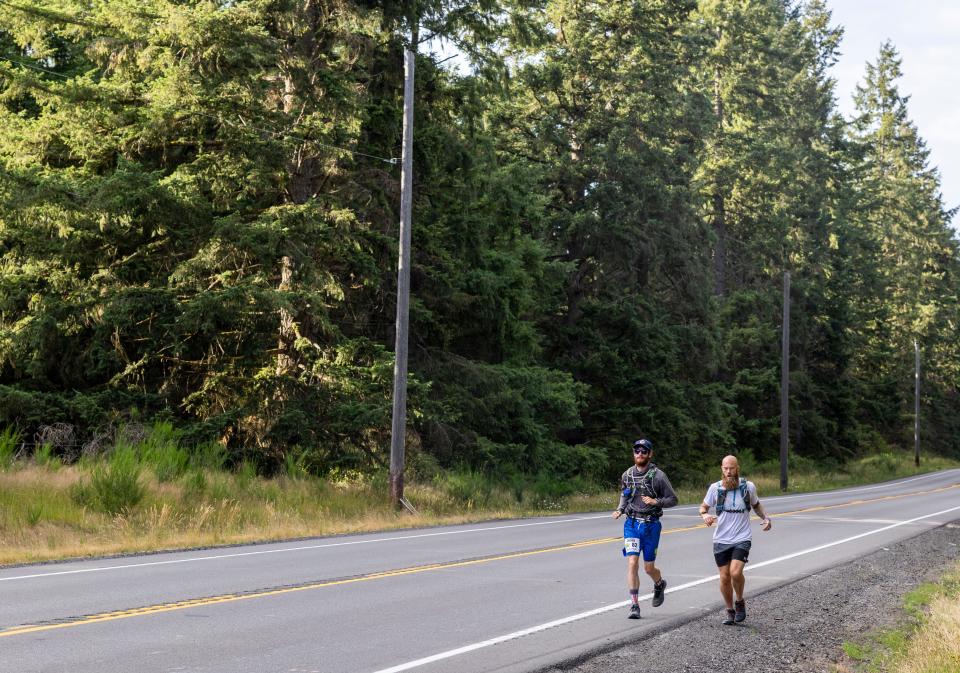 Greg Nance jogs with a friend along a road in Pierce County on July 15.