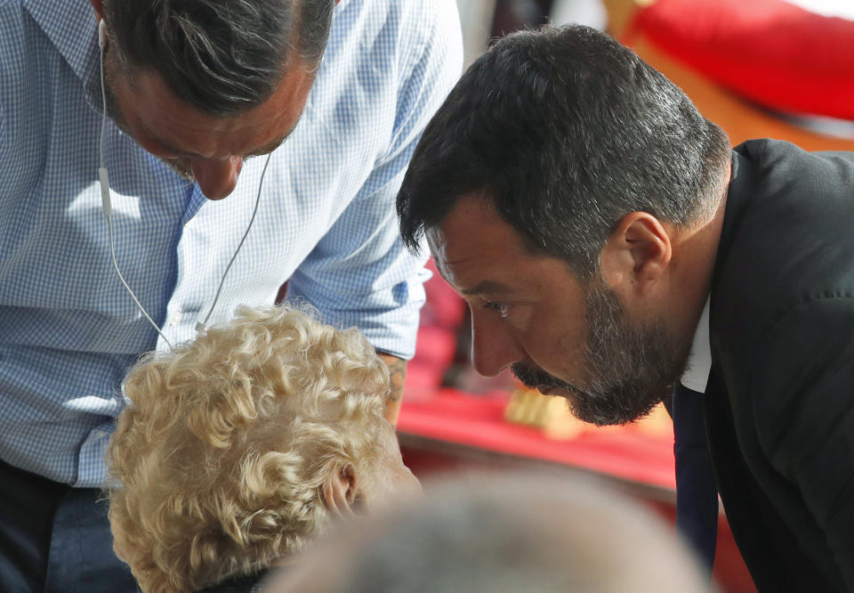 Italian Interior Minister Matteo Salvini greets a relative of a victim of the Morandi bridge collapse, during a remembrance ceremony to mark the first anniversary of the tragedy, in Genoa, Italy, Wednesday, Aug. 14, 2019. The Morandi bridge was a road viaduct on the A10 motorway in Genoa, that collapsed one year ago killing 43 people. (AP Photo/Antonio Calanni)