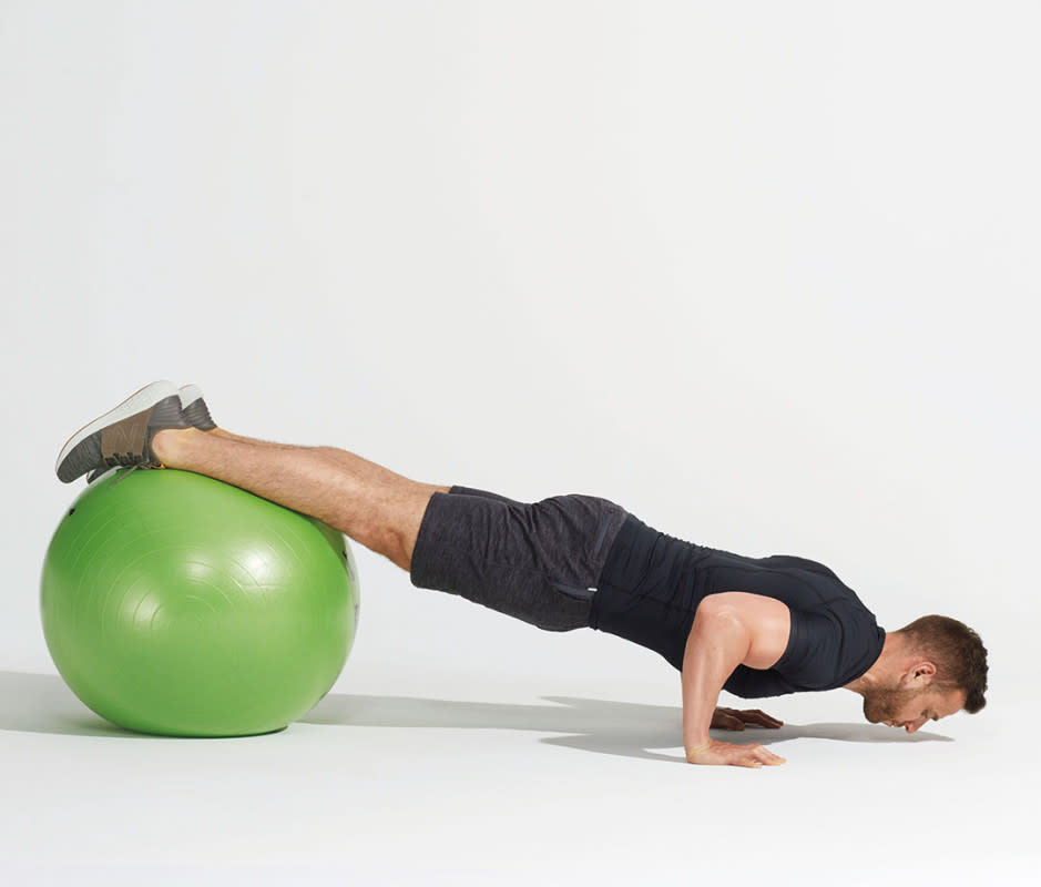 How to do it:<ol><li>Start with hands on the floor and slightly wide, top of feet or shins resting on a physio ball.</li><li>Engage core and lower body to stabilize, and perform pushups more slowly.</li></ol>