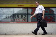 A person walks in front of an electronic stock board showing Japan's Nikkei index at a securities firm Wednesday, July 10, 2024, in Tokyo. (AP Photo/Eugene Hoshiko)