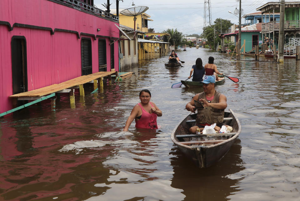 Residents navigate flooded streets in Anama, Amazonas state, Brazil, Thursday, May 13, 2021. (AP Photo/Edmar Barros)