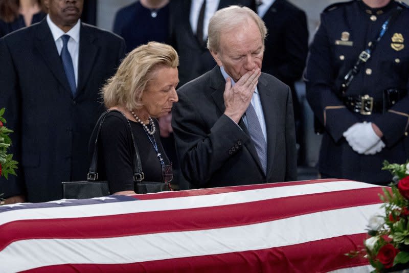 Former Connecticut Sen. Joe Lieberman, accompanied by his wife, Elizabeth Haas, gives a kiss to the casket of Sen. John McCain, R-Ariz., as he lies in state in the Rotunda of the U.S. Capitol, Friday, Aug. 31, 2018, in Washington, D.C. File Pool Photo by Andrew Harnik/UPI