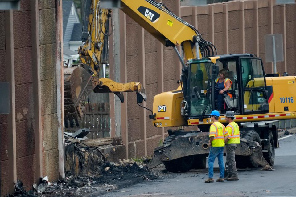 Workers are shown at the scene of an accident that occurred Monday, on Route 3 east, Tuesday, July 23, 2024. The accident resulted in the death of one driver and the breach of the sound wall.