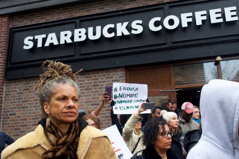 Protestors demonstrates outside a Starbucks with Black Lives Matter signs.