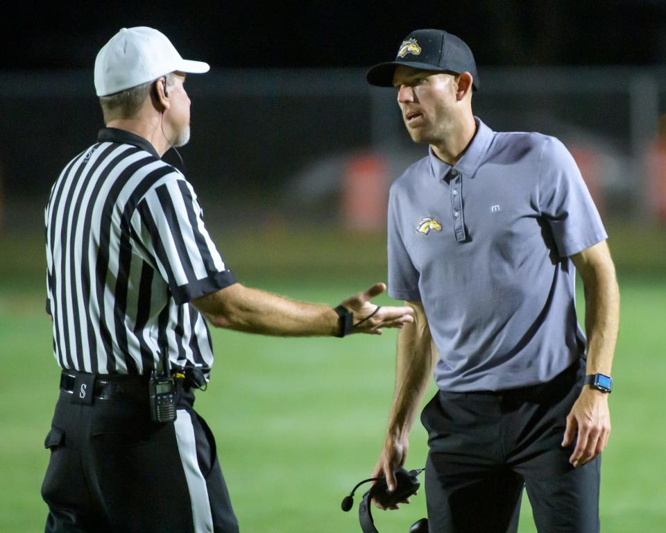 Former Chicago Bears kicker and Rolling Meadows head coach Robbie Gould discusses a penalty with an official as the Mustangs battle the Pekin Dragons in the second half of their opening night football game Friday, Aug. 30. 2024 at Pekin Community High School. The Dragons defeated the Mustangs 28-14.