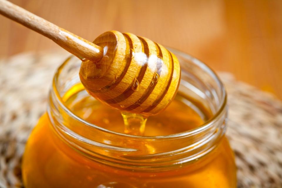 honey stirrer lifting honey from a jar