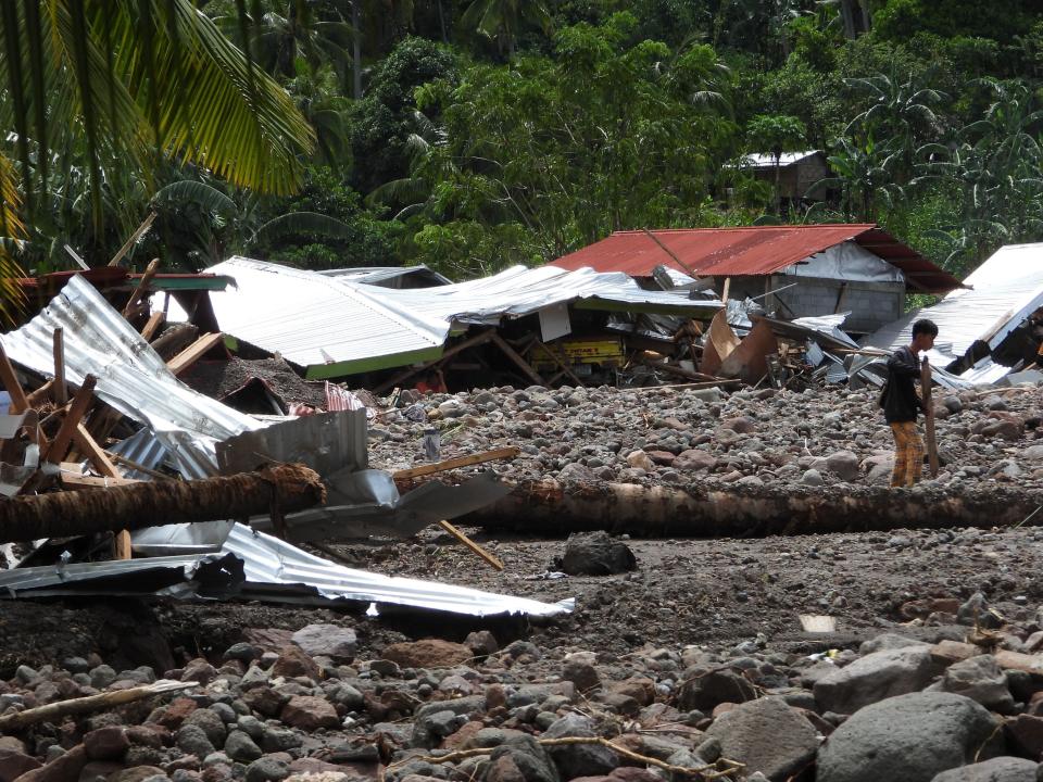 A resident walks past a destroyed house in the landslide-hit village of Kusiong in Datu Odin Sinsuat in the southern Philippines' Maguindanao province on October 29, 2022.