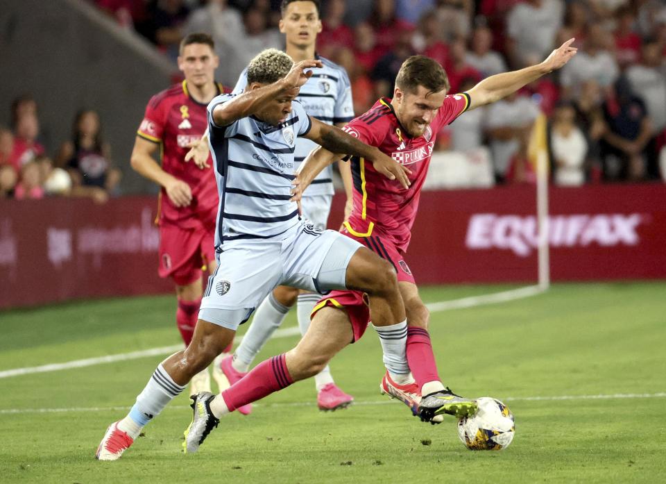 Sporting Kansas City defender Logan Ndenbe, left, and St. Louis City SC midfielder Indiana Vassilev compete for the ball during the first half of an MLS soccer match in St. Louis on Saturday, Sept. 30, 2023. (David Carson/St. Louis Post-Dispatch via AP)