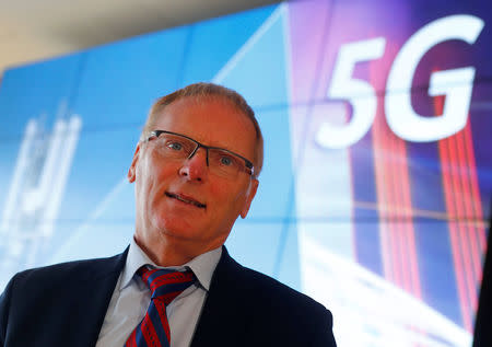 Jochen Homann, President of Germany's Federal Network Agency (Bundesnetzagentur) poses for a photograph in front of a screen set up for the auction of spectrum for 5G services at the Bundesnetzagentur headquarters in Mainz, Germany, March 18, 2019. REUTERS/Kai Pfaffenbach