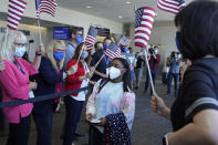 FILE - In this July 14, 2021 file photo, Simone Biles walks to her gate for her flight to the Summer Olympic Games in Tokyo as United Airlines employees wave flags during a send-off event for the U.S. Women's Gymnastics team at the San Francisco International Airport. Biles and Naomi Osaka are prominent young Black women under the pressure of a global Olympic spotlight that few human beings ever face. But being a young Black woman -- which, in American life, comes with its own built-in pressure to perform -- entails much more than meets the eye. (AP Photo/Eric Risberg, File)