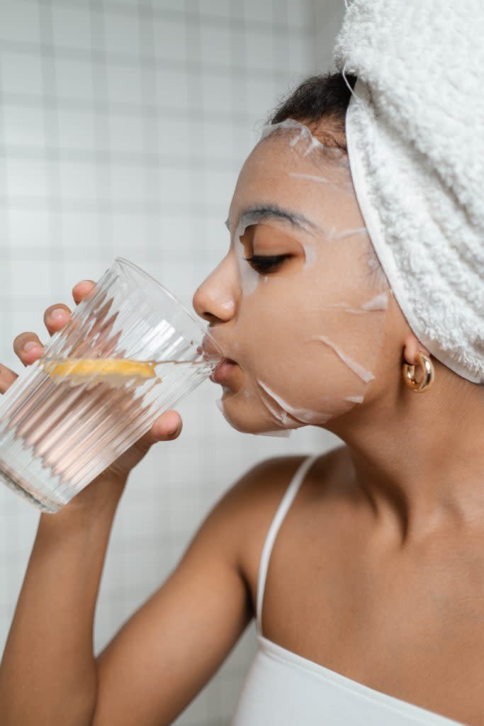 Black woman drinking a glass of water for weight loss