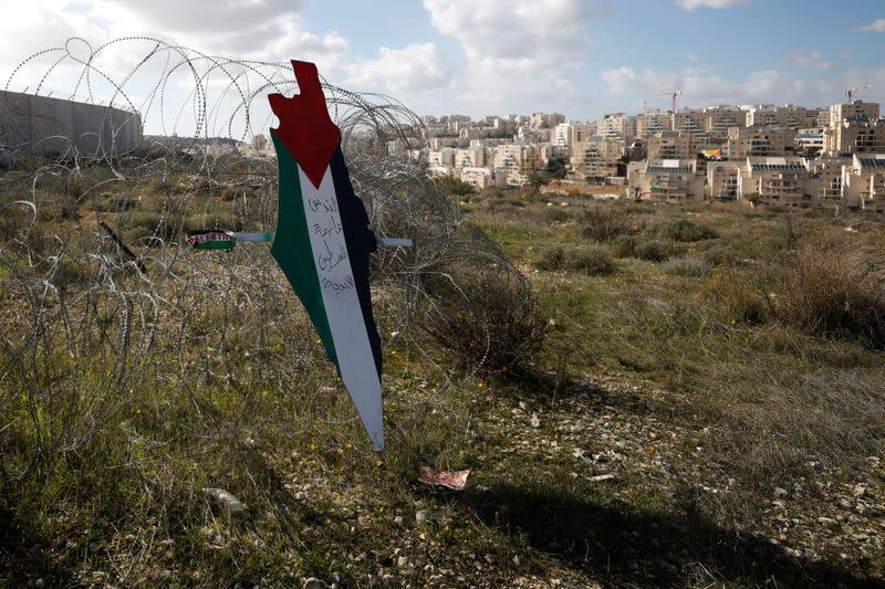 Representation of a map with the colors of the Palestinian flag is placed on a fence as a Jewish settlement is seen during a protest against Trump's Middle East peace plan, in the village of Bilin in the Israeli-occupied West Bank