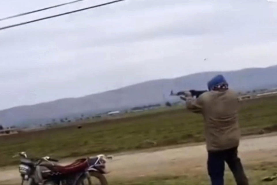 FILE - This Feb. 12, 2020, file frame from video, a Syrian man open fire on an American military convoy in the village of Khirbet Ammu, east of Qamishli city, Syria. Syria’s civil war has long provided a free-for-all battlefield for proxy fighters. But in its ninth year, the war is drawing major foreign actors into direct conflict, with the threat of all-out confrontations becoming a real possibility. (AP Photo/File)